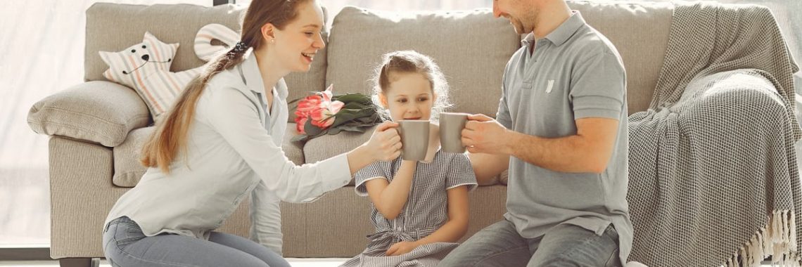A joyful family enjoying quality time and coffee in a bright living room, symbolizing love and togetherness.